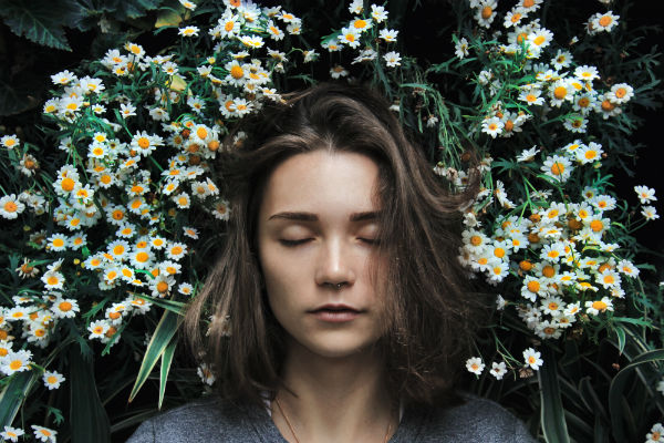 how to sleep better woman surrounded by flowers