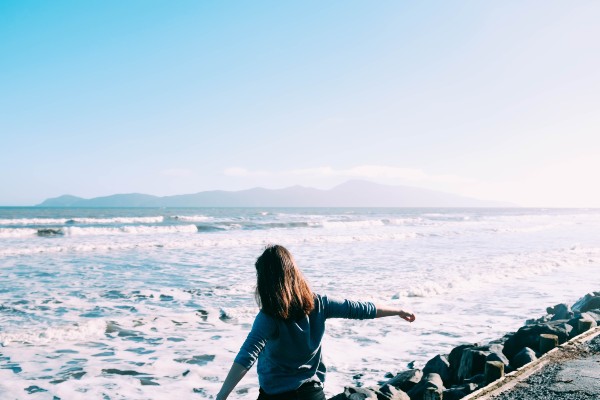 woman walking by the ocean in order to self-soothe